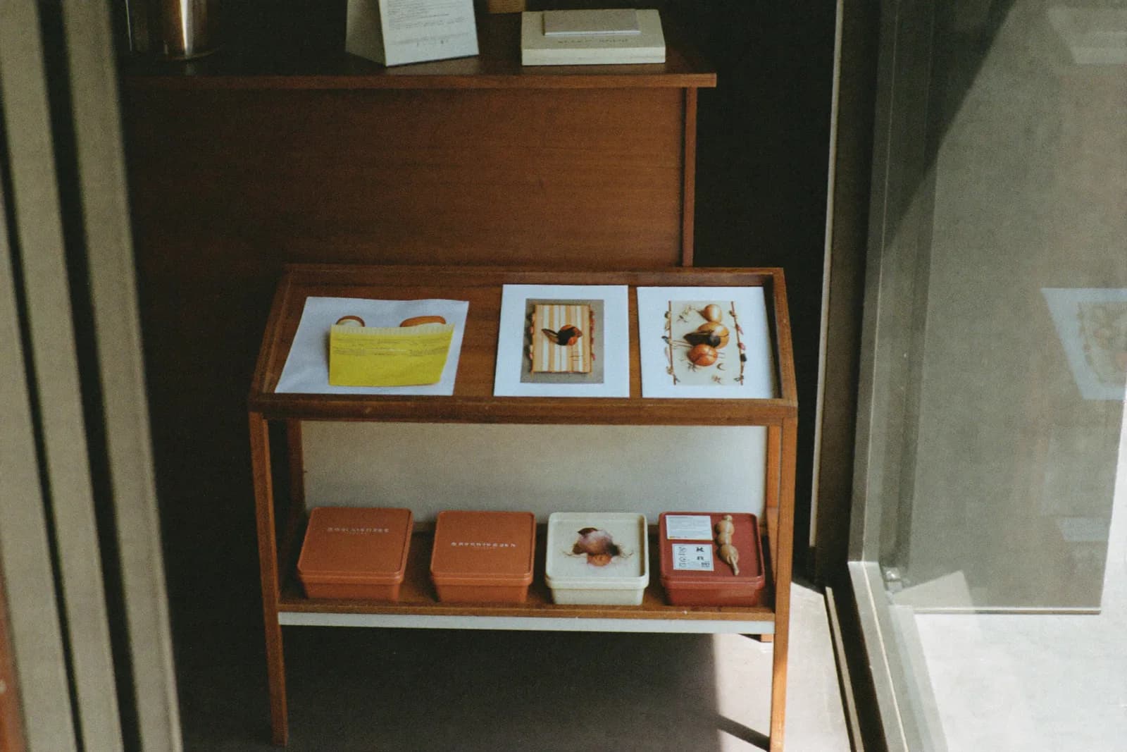 A small shop interior with sparse shelves along one wall and a working bench occupying most of the floor.
